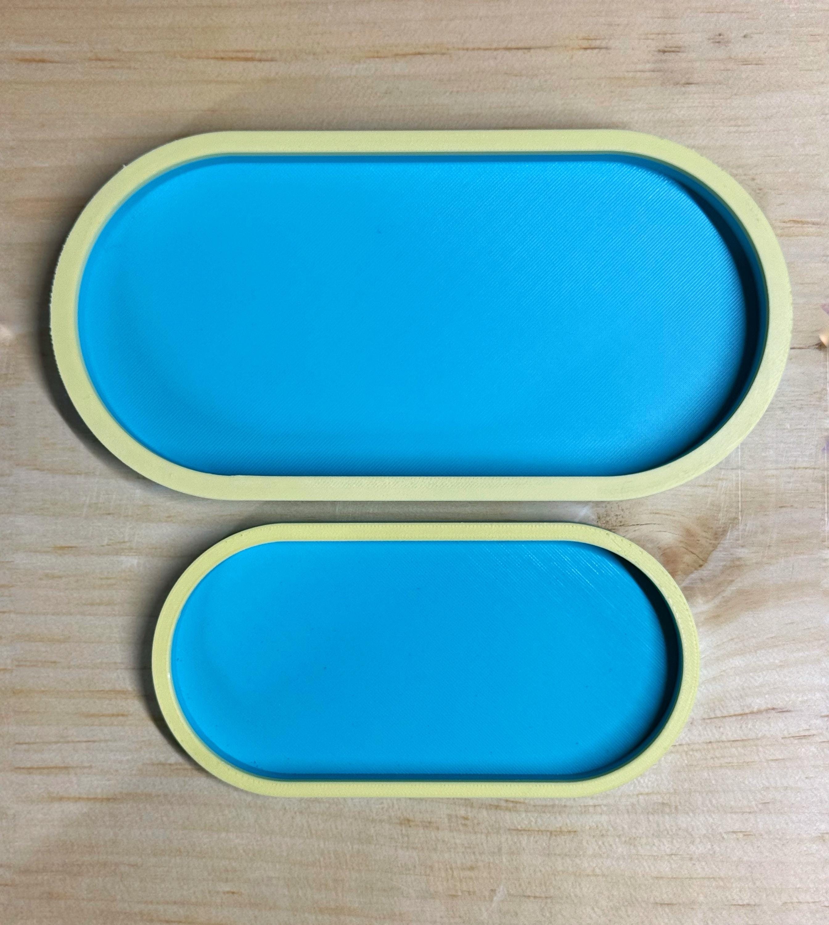 Large and small teal and yellow two-tone oval trays showing both sizes