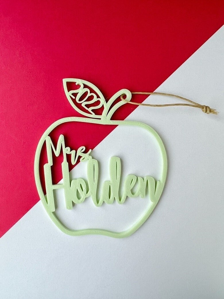 Mint green personalized teacher apple ornament reading Mrs Holden on a red and white background
