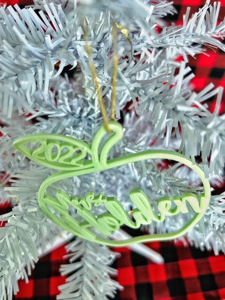 Mint green apple ornament reading Mrs Holden hanging on a white Christmas tree