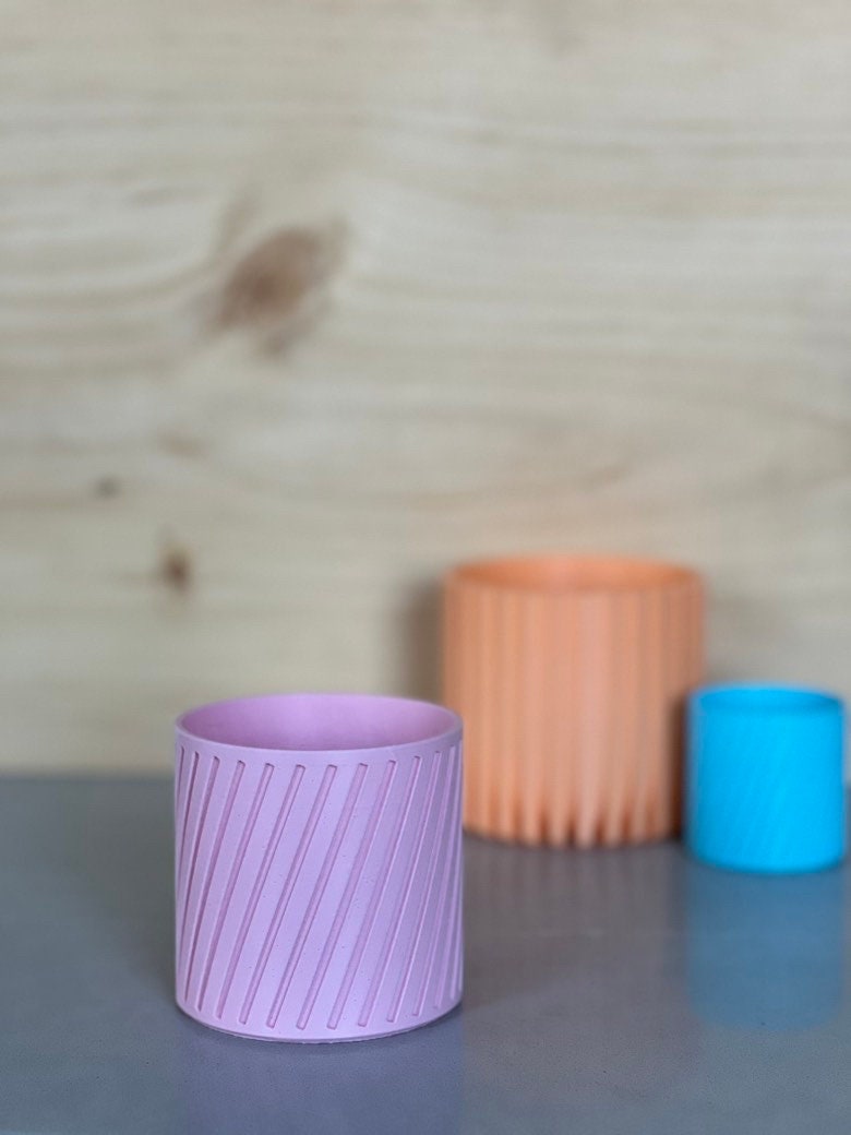Small purple-pink diagonal stripe 3D printed planter with peach and blue pots behind