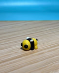 Yellow and black 3D printed Mini Flexi Bee fidget toy on a wood desk