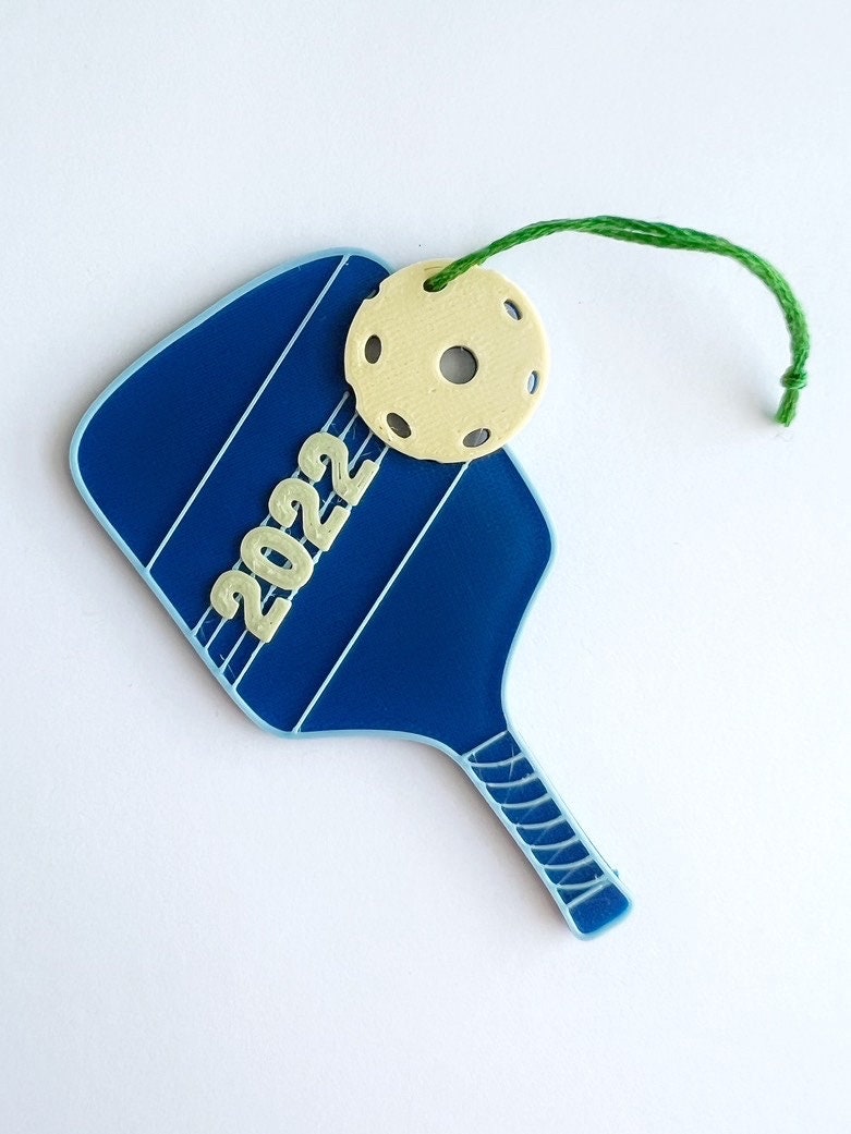 Blue pickleball paddle ornament printed with 2022 and a yellow ball