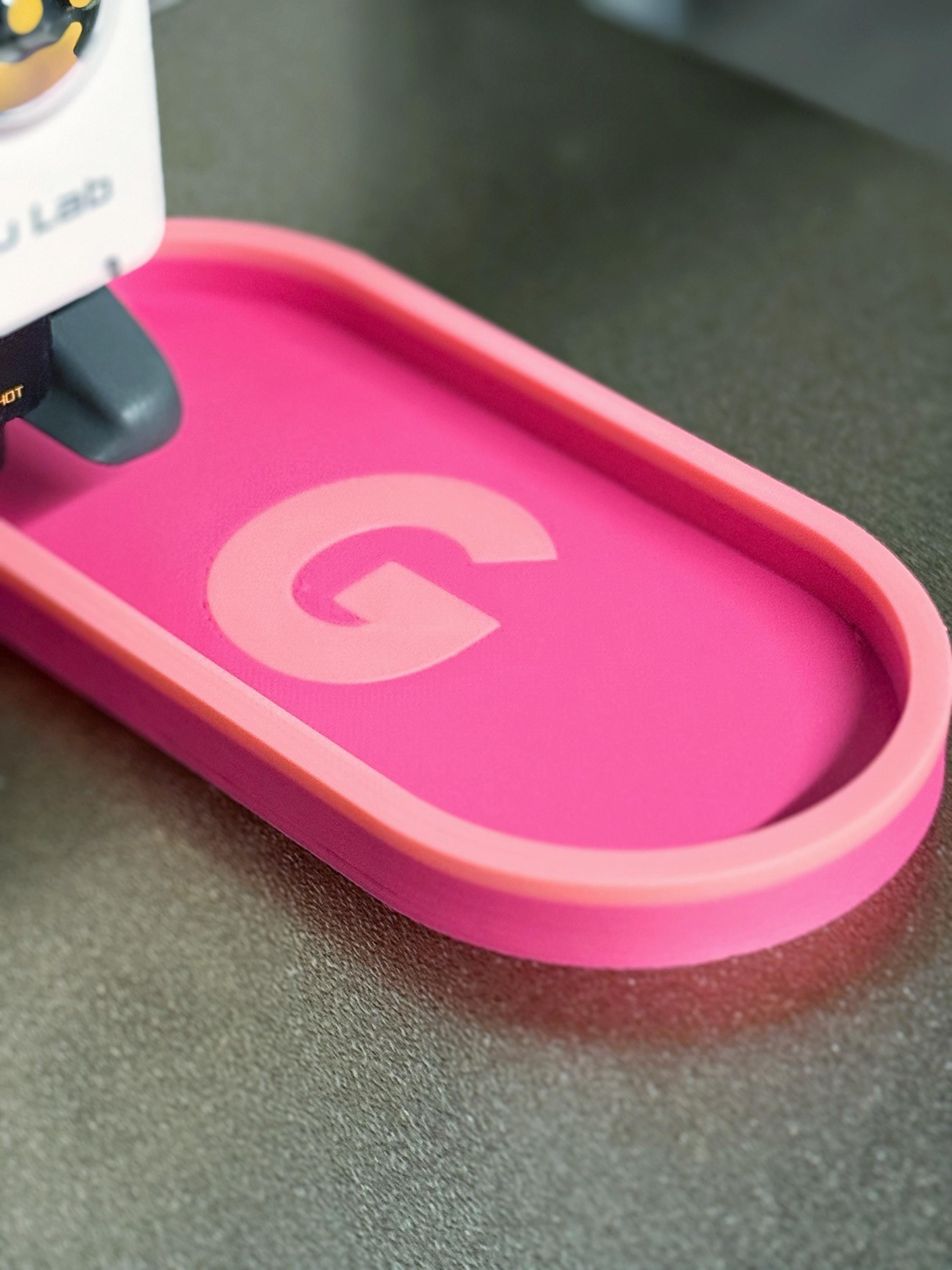 Pink personalized catch-all tray with the letter G on the 3D printer bed