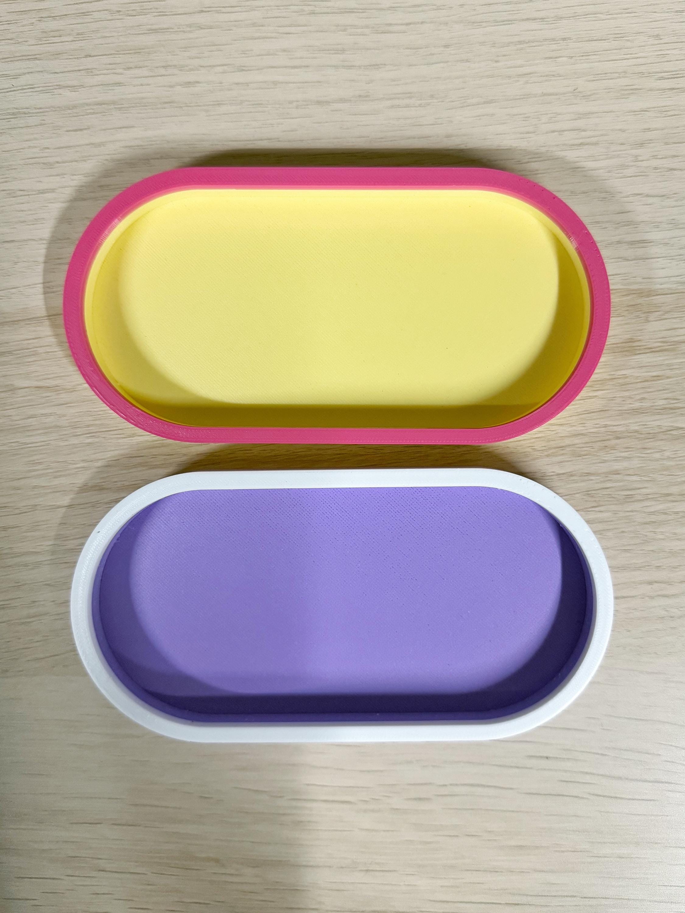 Yellow and magenta and purple and white two-tone oval trays, top view